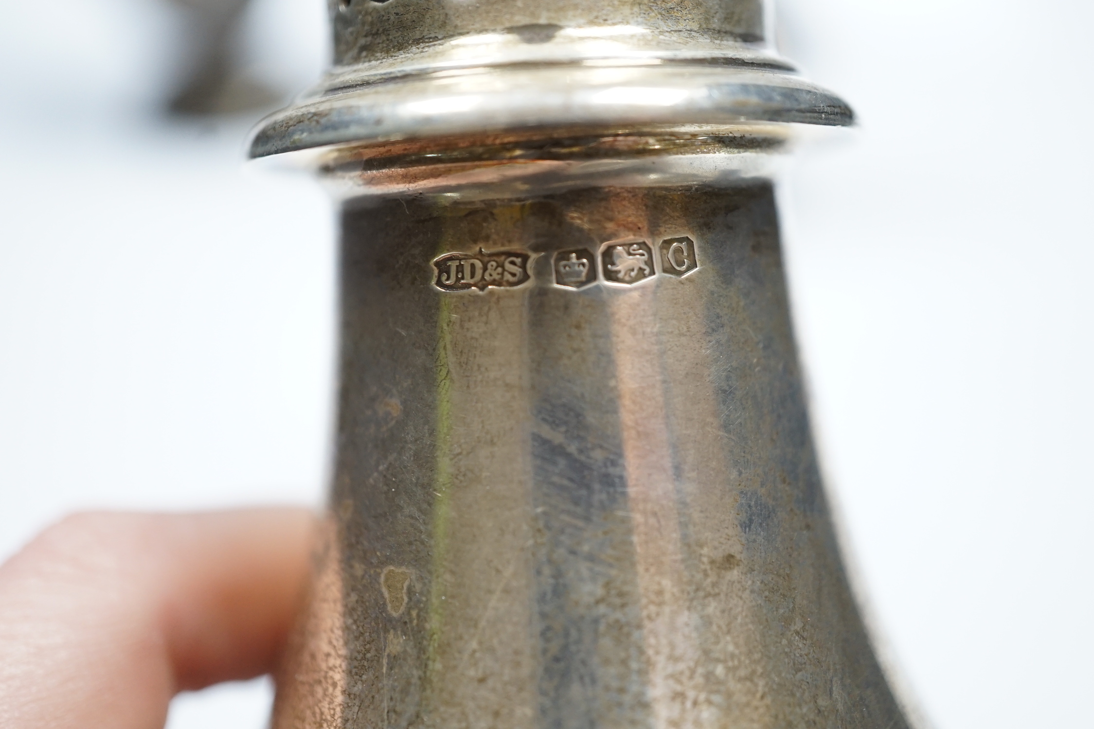 A pair of early to mid 20th century large silver sugar casters, marks rubbed, 23.8cm, weighted and two smaller silver sugar casters including George III, London, 1764.